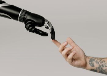 A robotic hand touching a human hand.